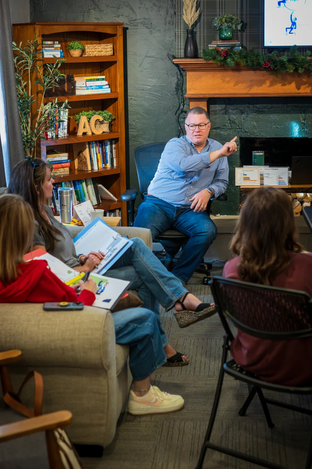 Vertical portrait of the male trainer pointing to illustrate a concept for seated attendees at the Wichita PCM® workshop.